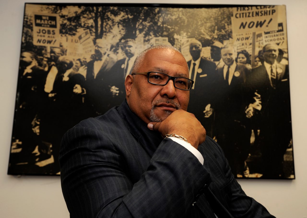 A portrait photo of Reverend Horace Sheffield, sat behind the desk in his office