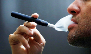 A man with an Iqos smoking device