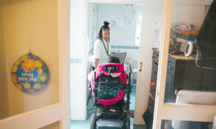 Lauren Campbell-Thompson helps twin sister Rianna into the bathroom of their Bromley home