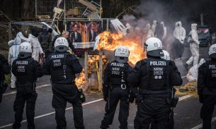 Riot police stand in front of burning barricades as activists stage a protest in Lützerath